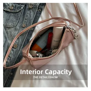 Interior view showing capacity of mini cylinder crossbody bag with makeup and lipstick