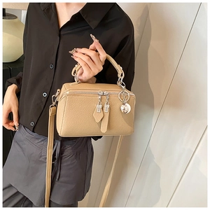 Detailed macro shot of beige Boston bag texture with silver zipper and sphere charm