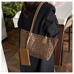 Leopard print tote bag with brown straps and small purse shown on a model