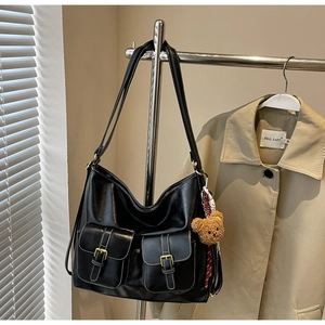 Detail of black faux leather tote with double front pockets and white contrast stitching