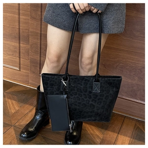 Macro detail of leopard print suede tote bag with leather straps and mini hanging pouch