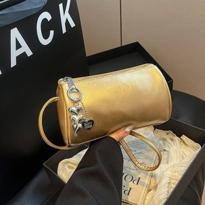 Gold metallic cylinder handbag with heart charm and shoulder strap for spring commute