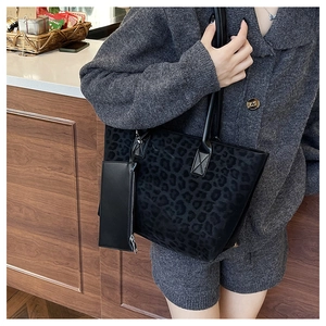 Detail of leopard print suede tote bag with matching zippered pouch on a long strap