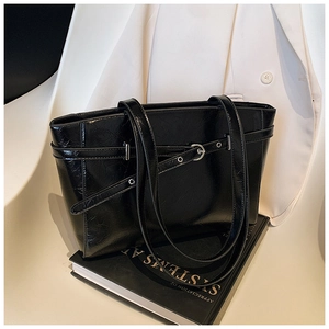 Nahaufnahme der schwarzen Leder-Tote-Bag mit schicker Schnalle und glänzender Textur