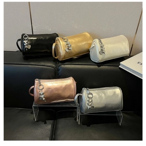 Detailed close-up of mini cylindrical bags in metallic colors with heart charms