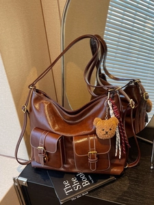 Brown vintage multi-pocket tote bag with plush bear charm and spacious capacity