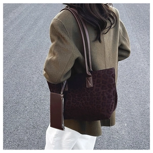 Close-up of leopard print suede tote bag set with matching pouch on a shoulder strap