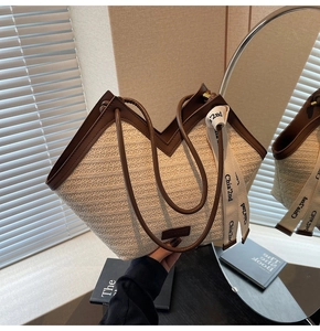 Dettaglio della borsa tote in paglia intrecciata con bordo in pelle a V e nastro