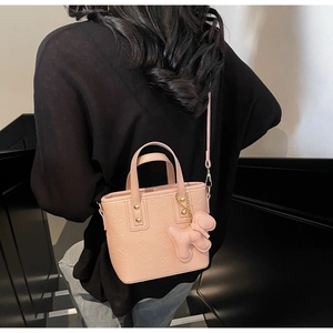 Borsa a secchiello in PU rosa con stelle a rilievo e ciondolo a cucciolo indossata