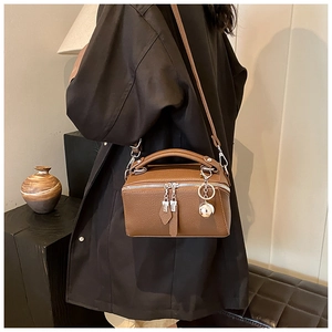 Brown lychee texture Boston bag with silver hardware and ball pendant on a model