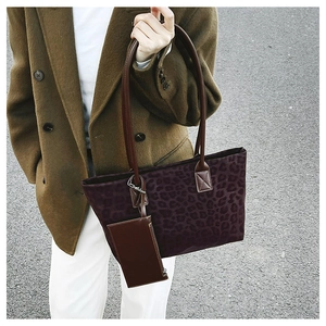 Detail of leopard print suede tote bag set with brown leather straps on model