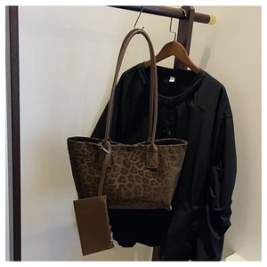 Detail of leopard print suede tote bag with matching coin purse on a wooden hanger