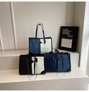 Dettaglio di borse tote color-block con manici in pelle su scalini in marmo