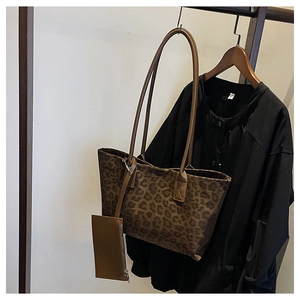 Detail view of leopard print suede tote bag with matching leather pouch and shoulder strap