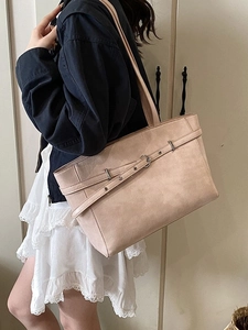 Modische beige Tragetasche mit Schnallendetail an einem Modell für Büro und Alltag