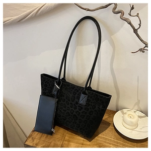 Detailed macro view of black leopard print suede tote bag with detachable mini pouch