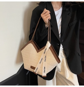 Dettaglio borsa shopper intrecciata con finiture in pelle marrone e nastro decorativo