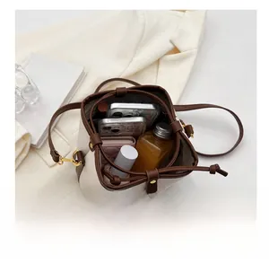 Detail view showing large capacity of the two-tone drawstring bucket bag for essentials