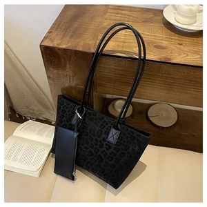 Detail of black suede tote bag with subtle leopard print and matching coin purse pouch