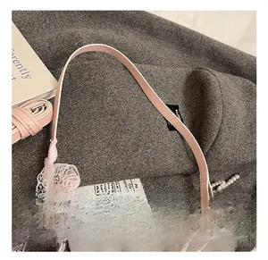 Détail du sac plissé avec nœuds en dentelle rose, perles et rubans décoratifs