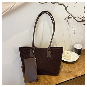 Deep brown leopard print suede tote bag with matching pouch on a wooden tabletop