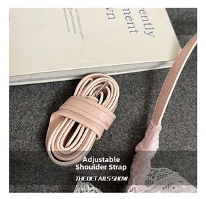 Détail de la bandoulière réglable en cuir rose avec bordure en dentelle blanche