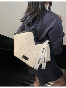 Borsa tote in paglia intrecciata minimalista con bordo nero e tracolla lunga per la spiaggia