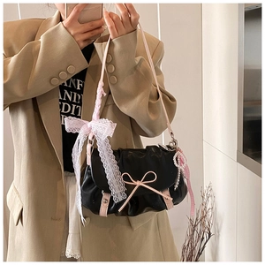 Détail du sac nuage noir avec nœuds en cuir rose, dentelle blanche et perles