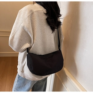 Detailed back view of a black crescent crossbody bag worn by a model for daily use
