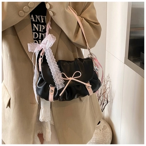 Détail du sac nuage plissé noir avec des nœuds roses et des rubans en dentelle blanche