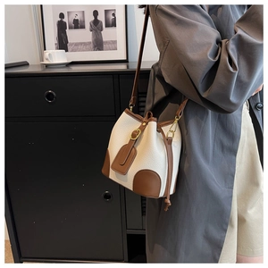 Detail of white and brown bucket bag with lychee texture and adjustable shoulder strap
