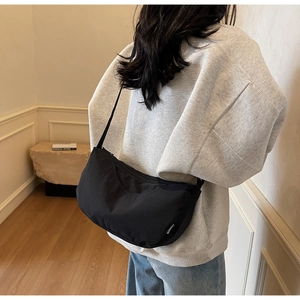 Detailed back view of a black crescent nylon crossbody bag with fashion label
