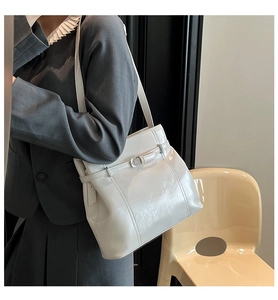 Détail du sac à épaule en cuir verni blanc avec finition brillante et boucle en métal