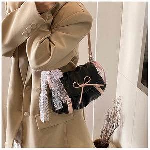 Détail du sac nuage plissé noir avec nœud rose, rubans en dentelle et perles