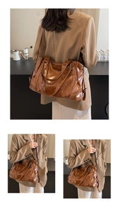 Close-up of vintage brown oversized tote bag with soft pleated synthetic leather texture