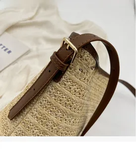 Detail of adjustable brown leather strap and woven texture on summer straw bucket bag