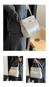 Vue détaillée d'un sac cabas crème brillant avec une boucle métallique élégante et chic