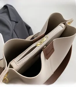 Close-up of golden zipper hardware and interior compartment of the beige tote bag