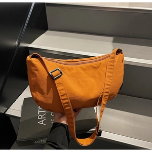 Close-up of mustard yellow nylon hobo bag with adjustable strap and smooth fabric texture