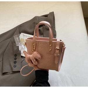 Dettaglio ravvicinato della borsa a secchiello rosa con goffratura a stella e ciondolo