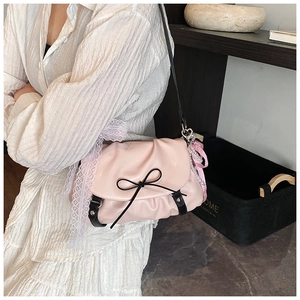 Détail du sac nuage rose avec nœud noir, bordure en dentelle et ruban élégant