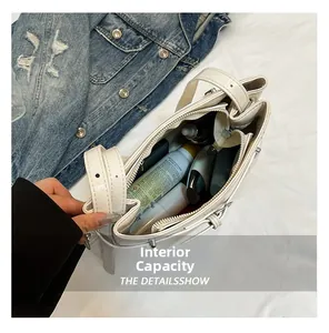 Vue du dessus de la capacité intérieure du sac en cuir blanc avec produits de beauté
