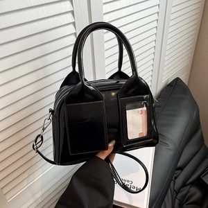 Sac coquille noir brillant avec doubles poignées et poches décoratives à l'avant