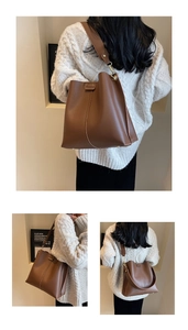 Detailed macro view of brown leather bucket bag with wide strap and vertical stitching