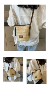 Detail of woven straw bucket bag with dark brown leather trim and adjustable shoulder strap