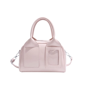 Sac à main rose avec poignées rondes et fente pour carte sur une surface en cuir mat
