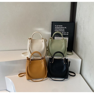 Minimalist bucket bag set in four colors on display stands with elegant long straps