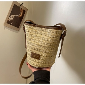 Straw woven bucket bag with brown leather strap for summer beach beach vacation style