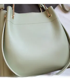 Detailed close-up of light green bucket bag showing smooth PU leather and gold metal ring