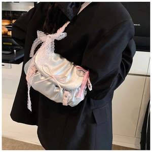Détail du sac argenté métallisé avec bandoulière en dentelle rose et nœud